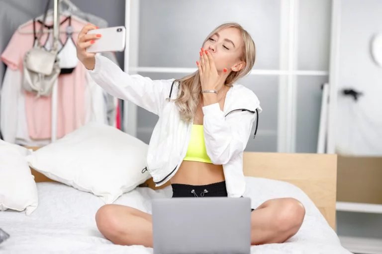 Keine Likes für Instagram 4 Young pretty girl blogger dressed in fashionable clothes takes a selfie on her smartphone for her