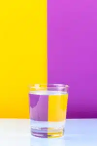 Optical illusion with glass of water and colorful paper