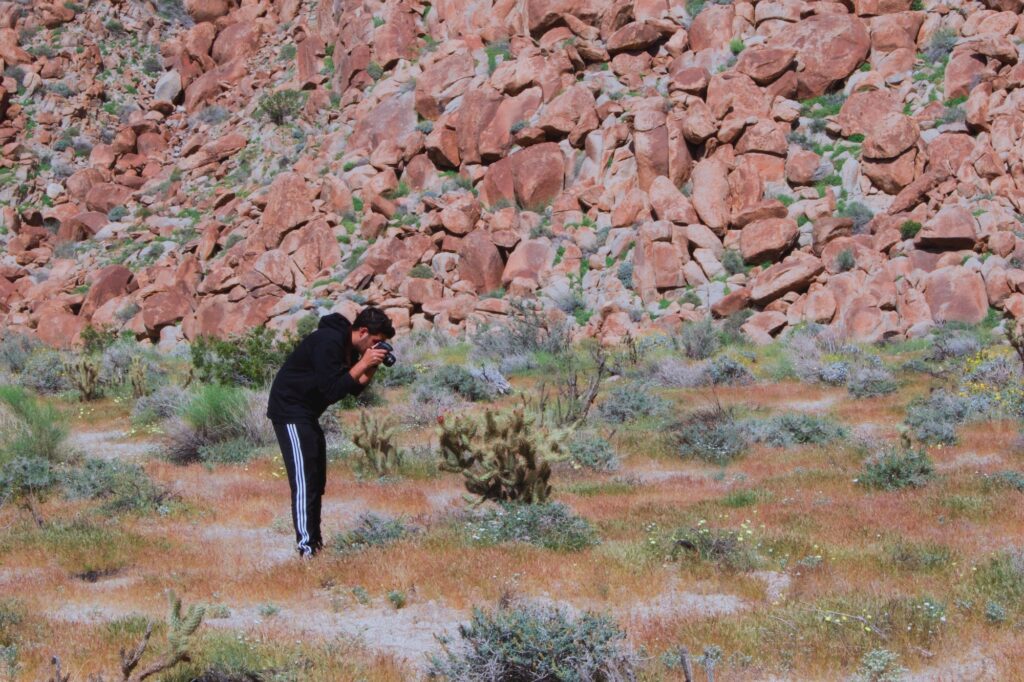 Photos in the desert. Man leaning over for the perfect shot