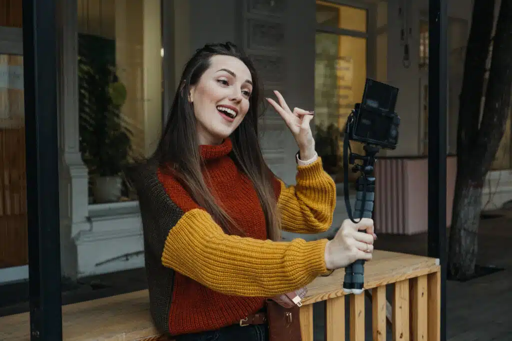 Content creator, blogger, vlogger young woman taking selfies, filming herself and having fun on city